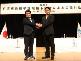公開討論会後、握手する砥板氏と中山氏＝４日夜、石垣市民会館大ホール