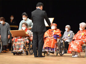 １０８歳の茶寿の皆さんに賞状を手渡す中山市長＝１２日、石垣市民会館大ホール